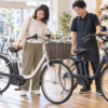 電動自転車の購入先を店頭で比較する様子