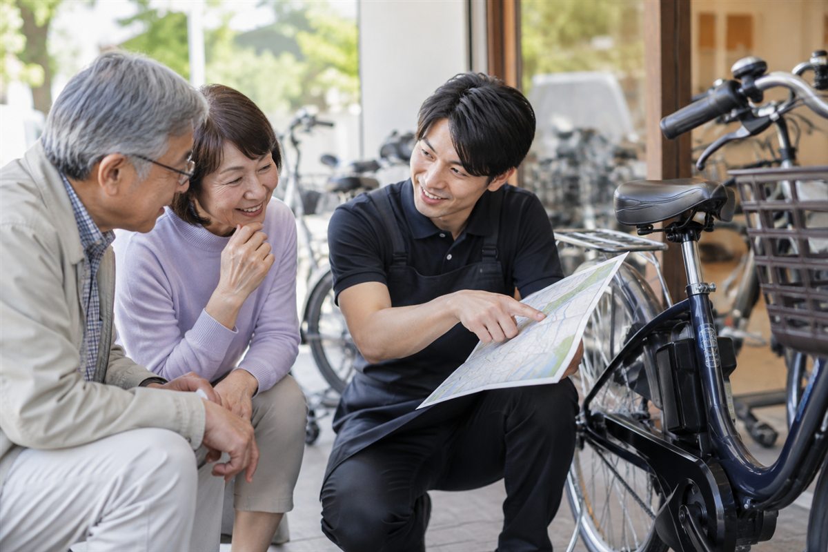 どこをどのくらい走るかについて相談する電動自転車の利用者
