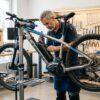 自転車プロショップで電動アシスト自転車のリアキャリアとチャイルドシート適合性を点検する風景